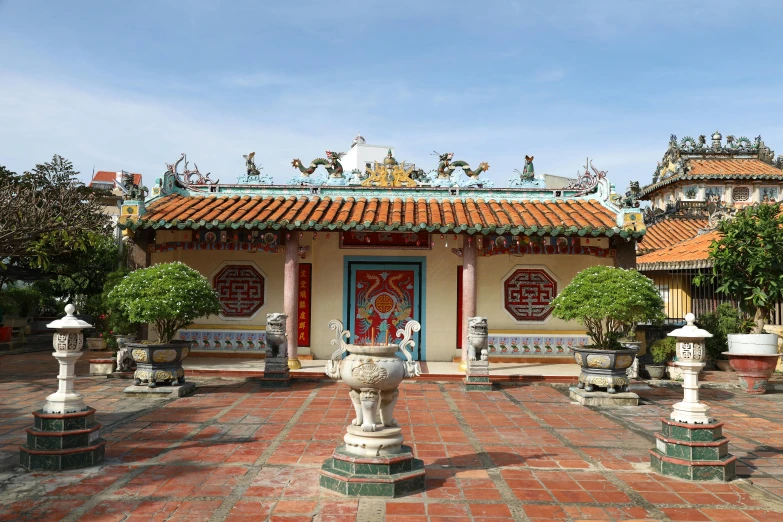 an ornate building with benches, potted plants and statues on the ground