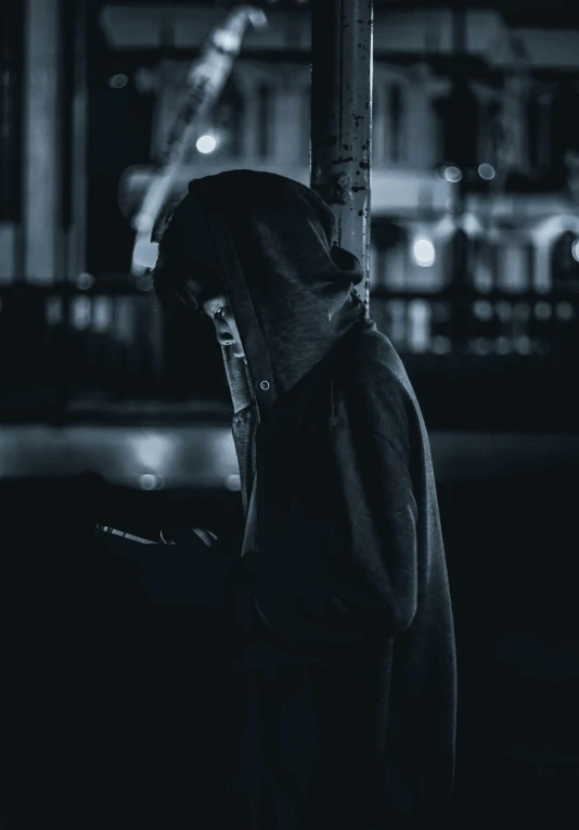 a hooded hooded person next to a street lamp