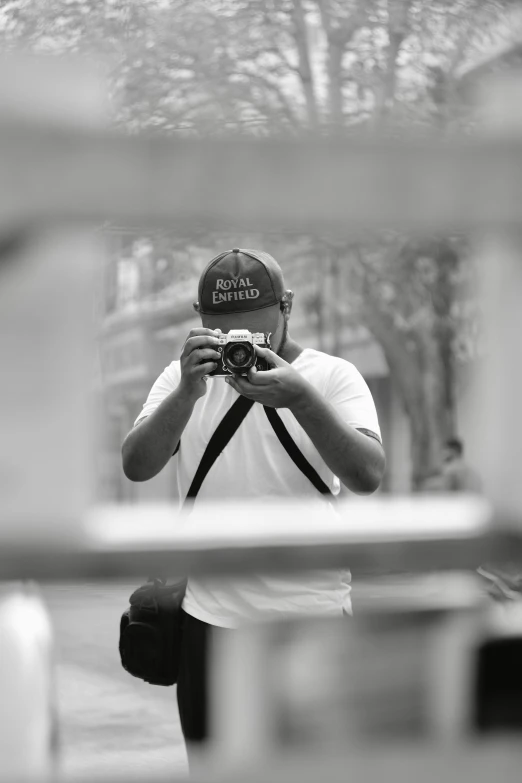 man taking picture through mirror in the middle of park