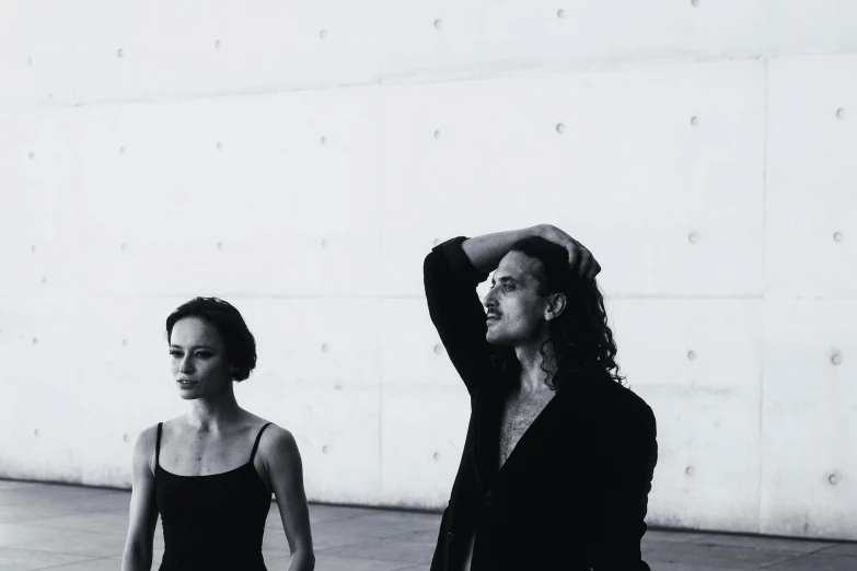 a man and woman standing in front of a large wall