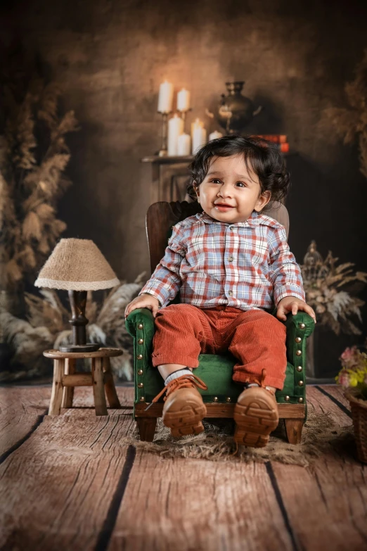 a toddler sitting on a chair with red pants