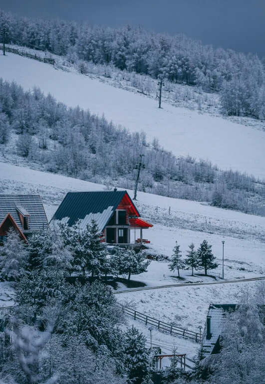 there are several snow covered buildings on the hill