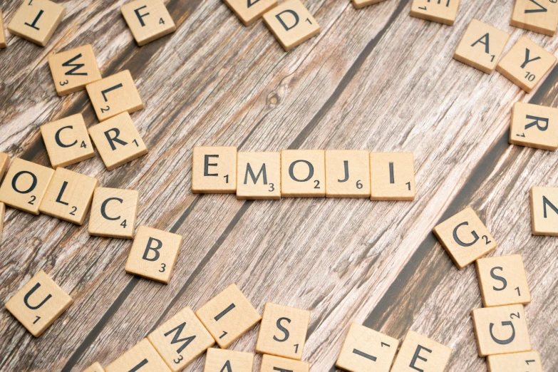 small scrabble tiles are arranged around letters that spell out the word emotion