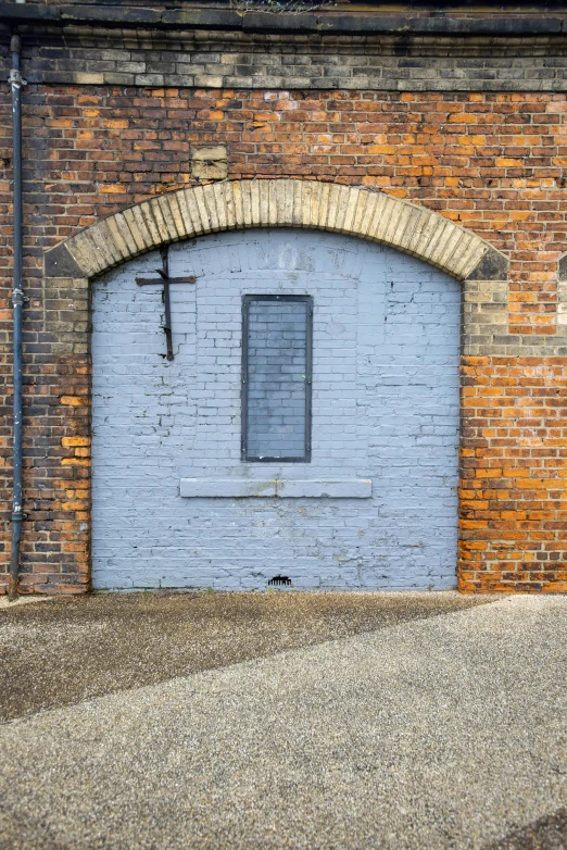 the blue brick facade has a cross on it