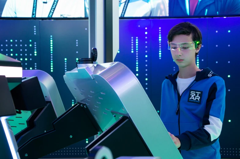 man in blue jacket standing next to large computer parts