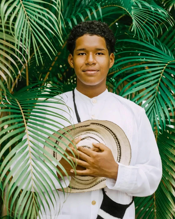 an african american male in a white shirt and black tie is holding a hat