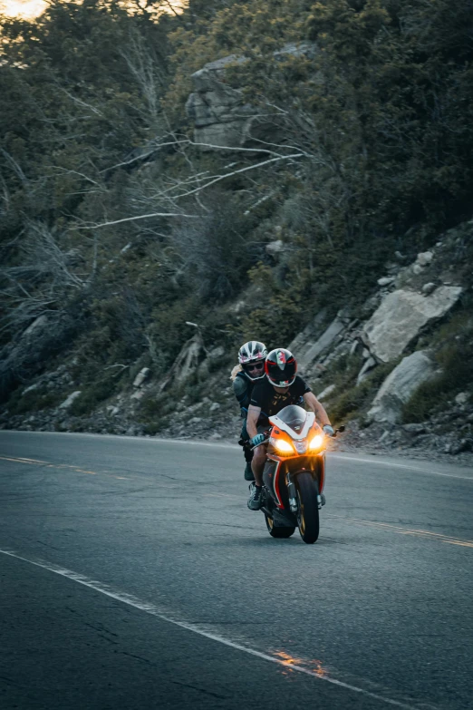 two people riding motorcycles on an empty road