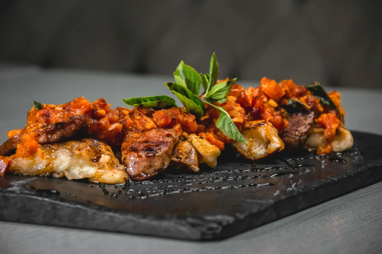 meat and vegetables sitting on a plate covered in sauce