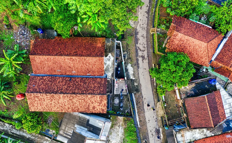 the aerial view from above of red tiled roofs in rural village