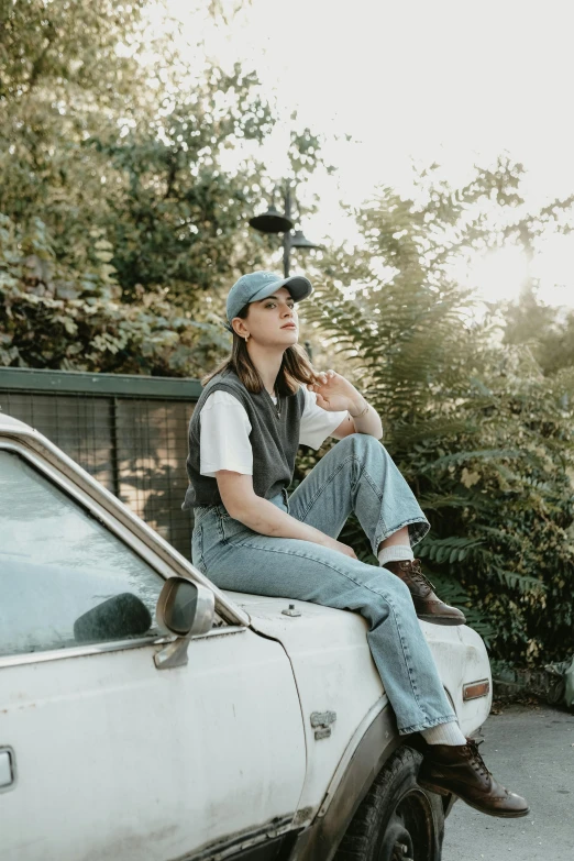 a person sitting on the back of a truck with a cigarette in their mouth