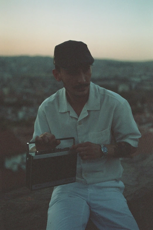 a man with a briefcase and cap on the mountain