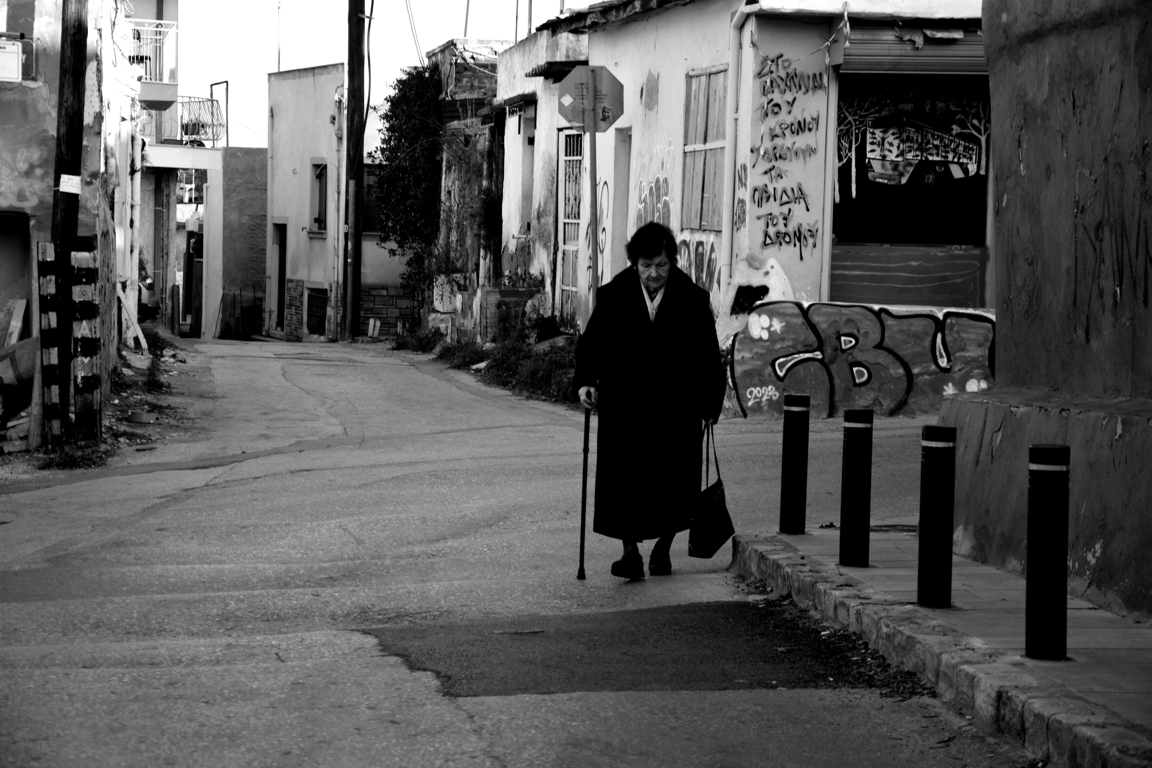 a man is walking down a street with a rolling suitcase