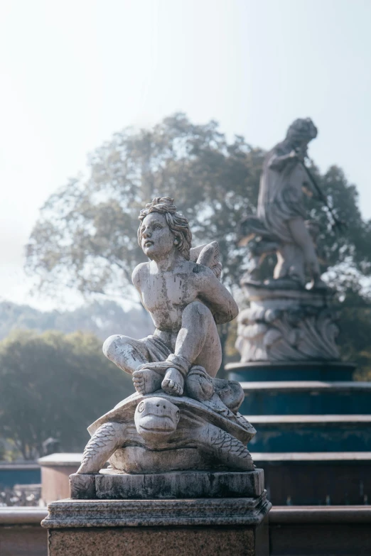 a statue stands in the middle of a park