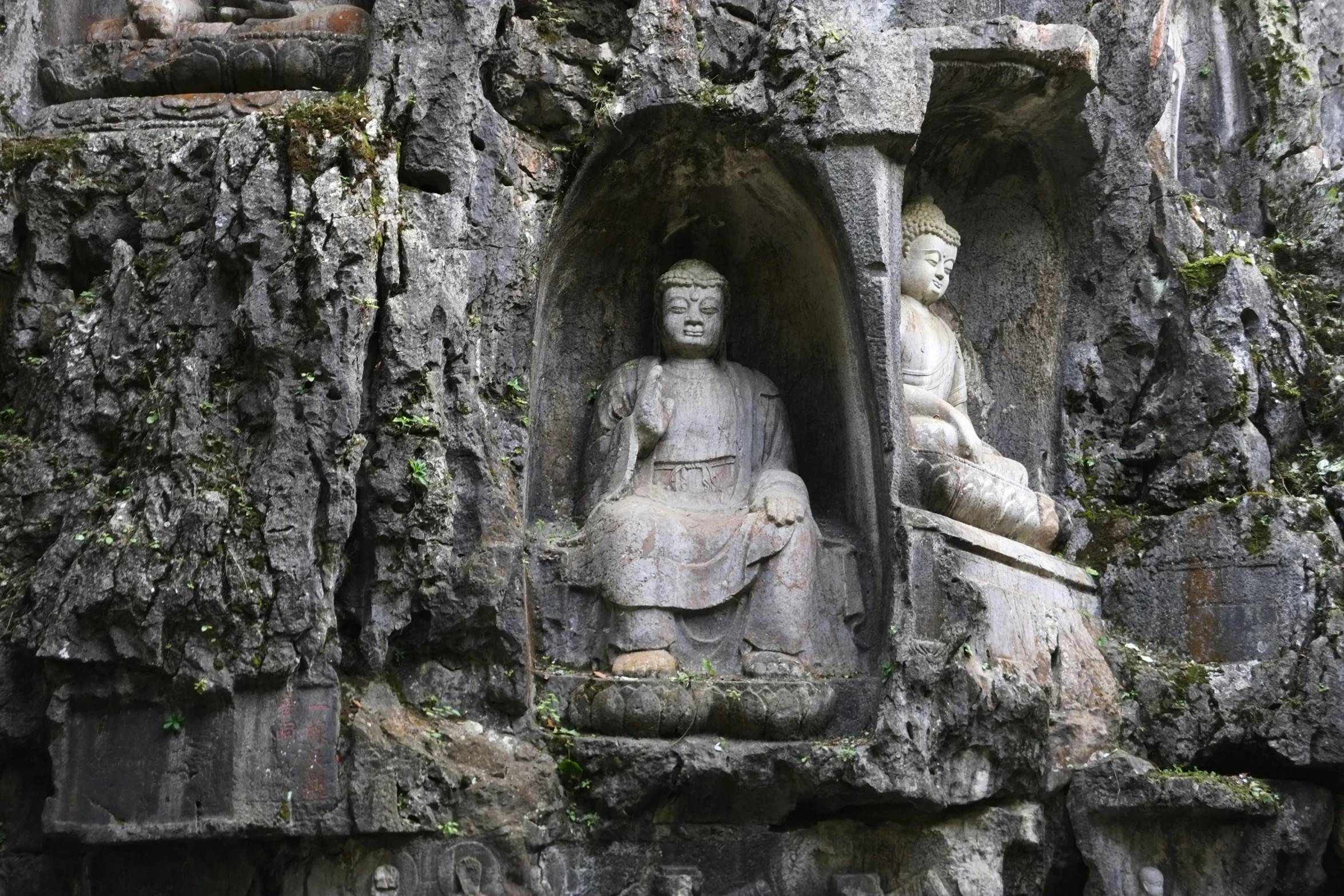 some statues in the cave on a mountain side