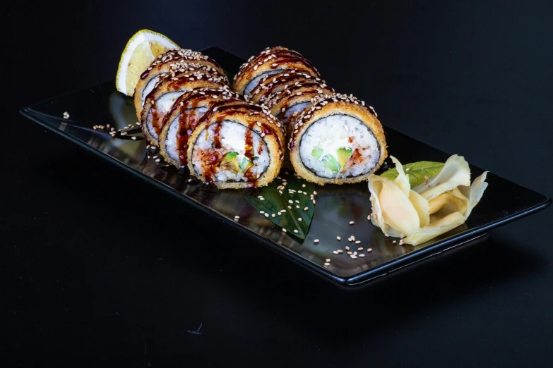 three large rolls on a black tray on top of a table