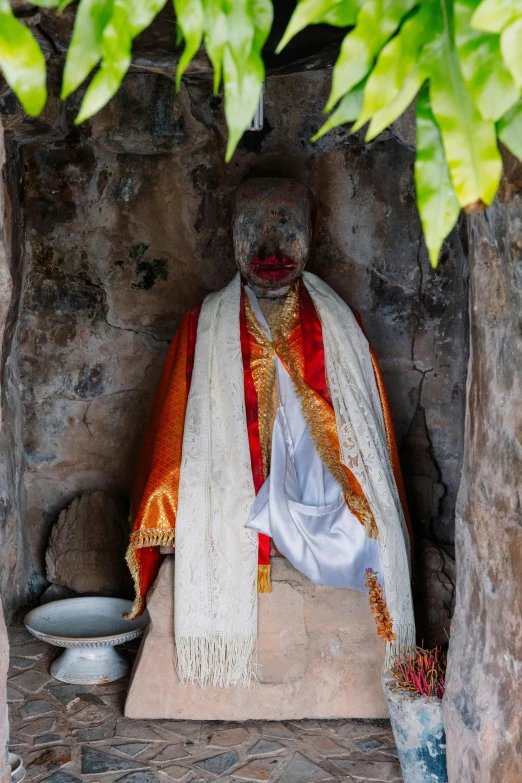 a statue of a man with a white robe and a red cape