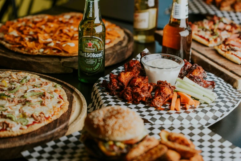 several various pizzas and chicken meat at an outdoor restaurant