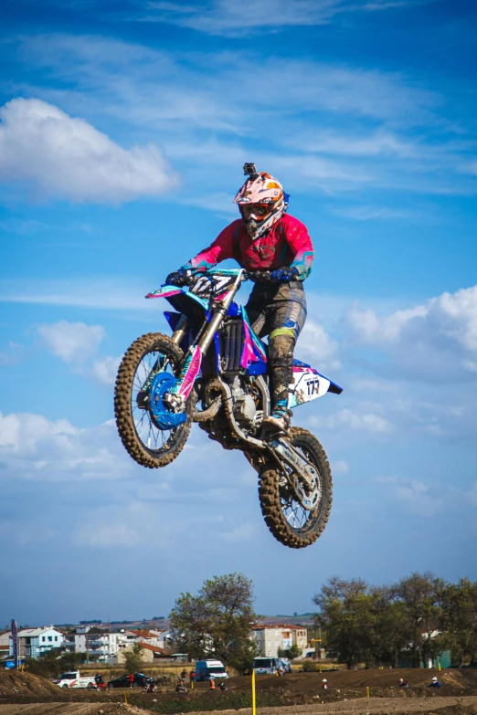 a person in a red shirt is jumping on a motorcycle