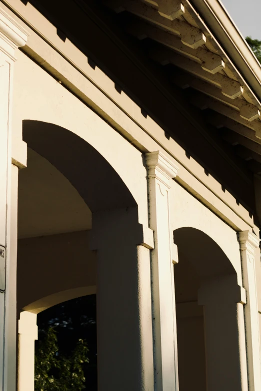 the sun is shining down over the arch on a building