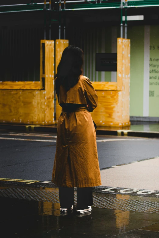 a person in an orange dress waiting on the street