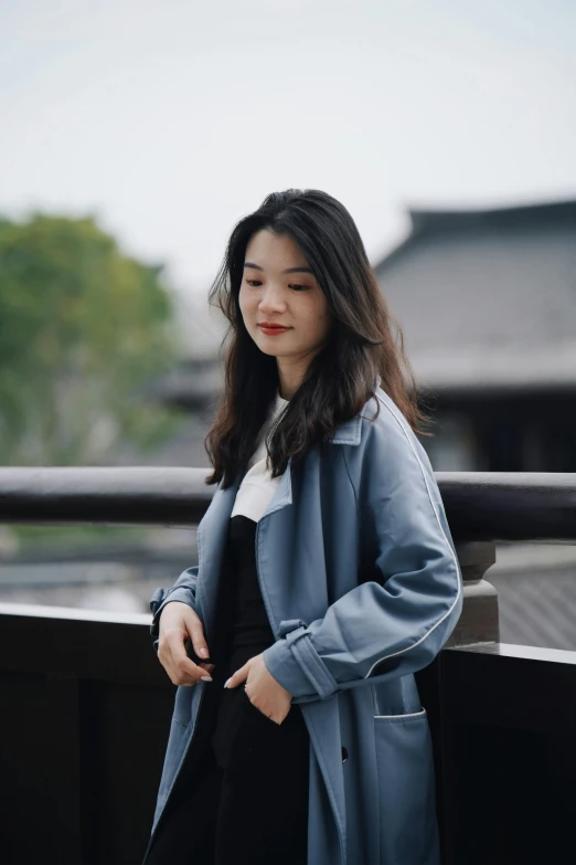 a woman standing on top of a wooden balcony next to trees