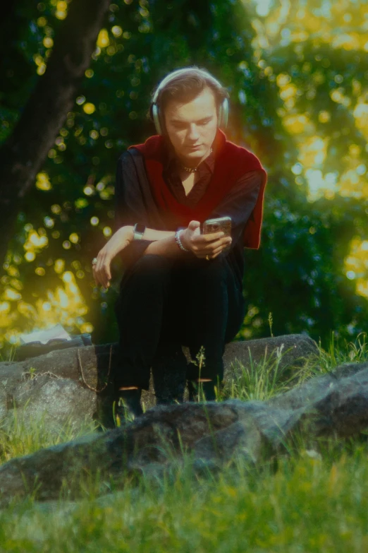 a man kneeling on top of a lush green field