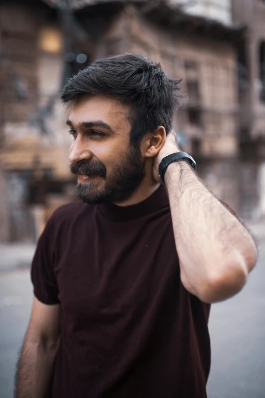 a man smiling with a tattoo on his arm