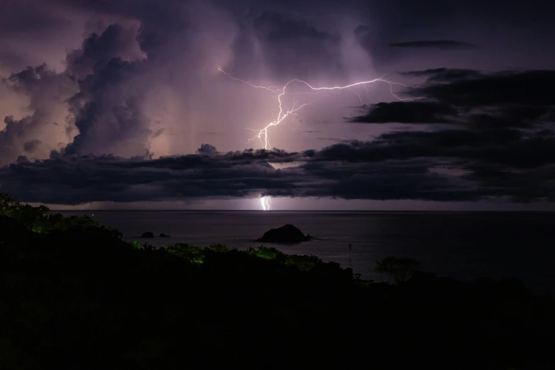 a lightning in the distance is seen with the lights of an object out in the distance