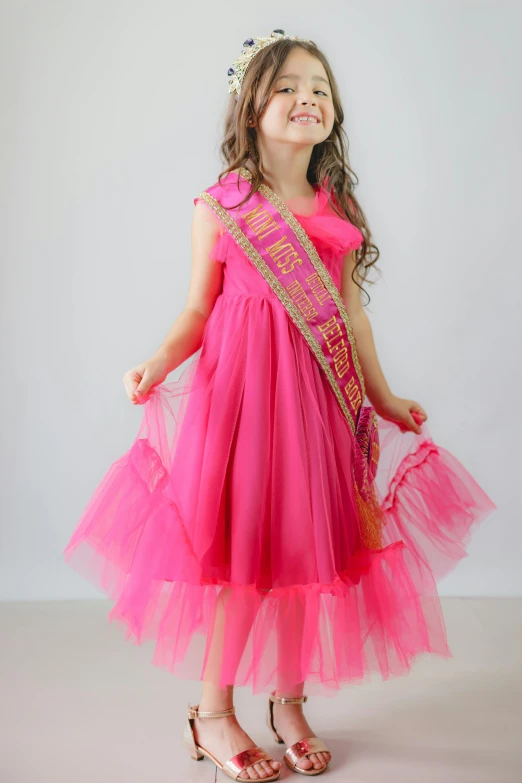 a little girl is wearing a  pink dress