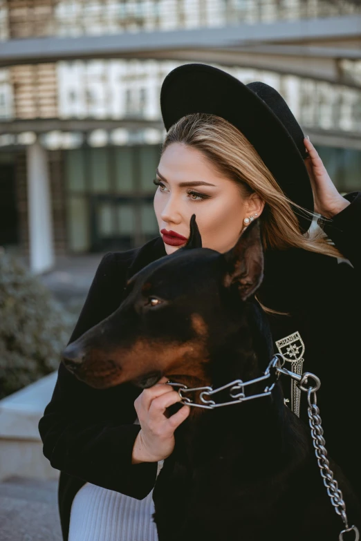 a woman with her dog on a leash and hat