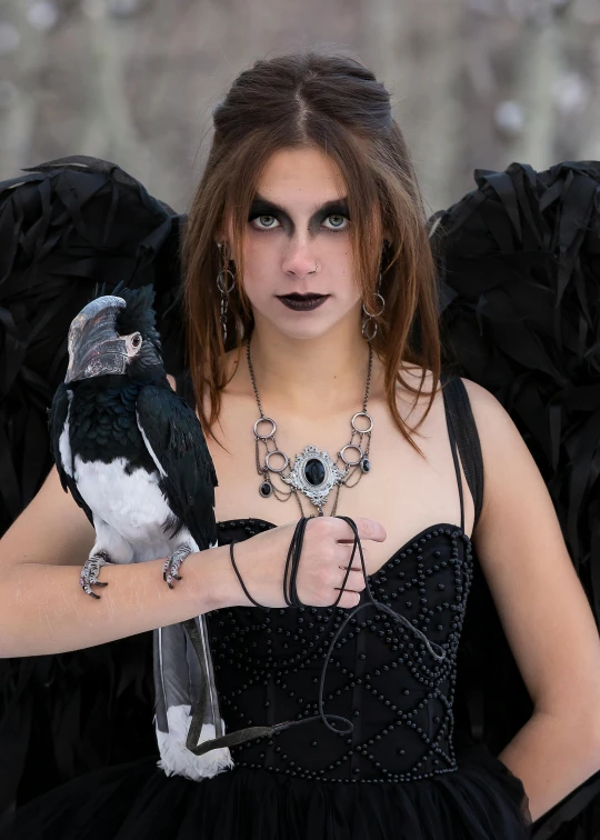 a girl dressed as a raven with an attached celet