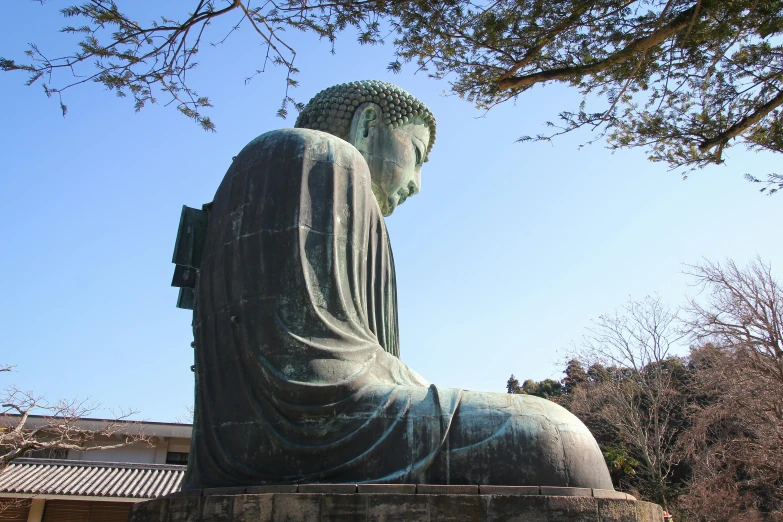 a large statue with a person looking down at it