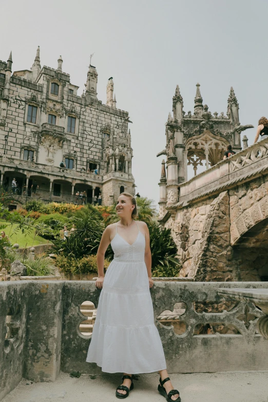 a woman posing in front of a castle