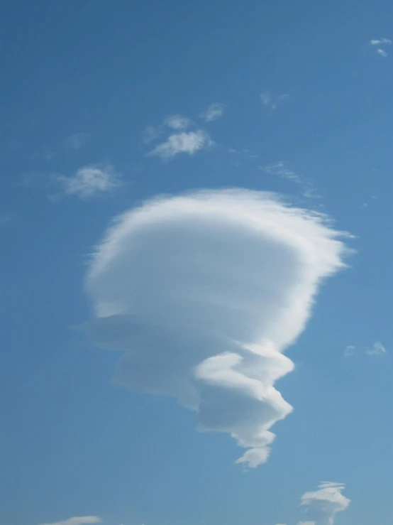 the cloud is forming a triangular shape in the sky