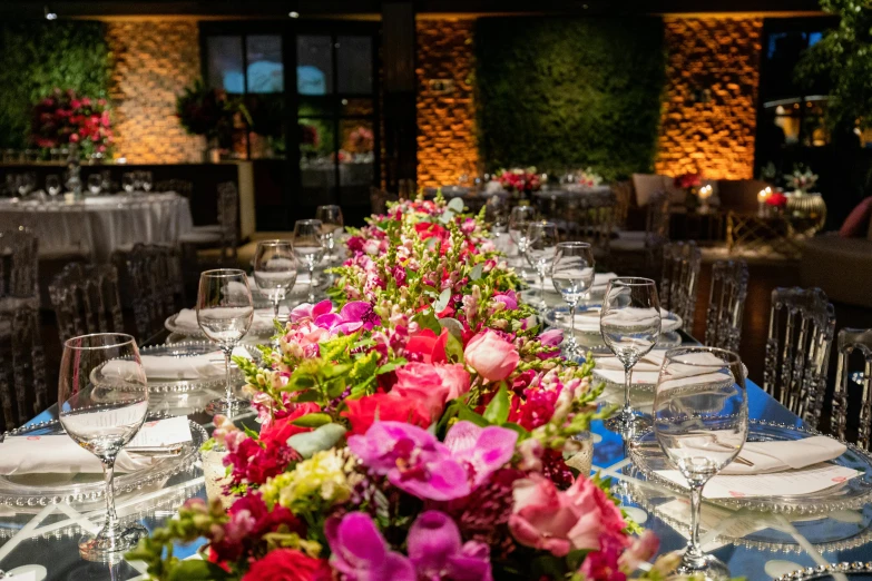 tables are set with tall centerpieces that are filled with pink and white flowers