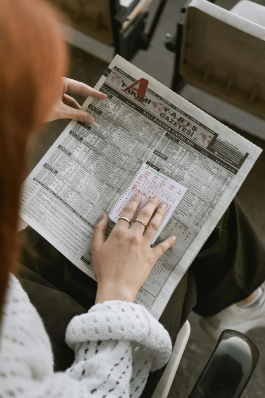 the woman is holding up a newspaper