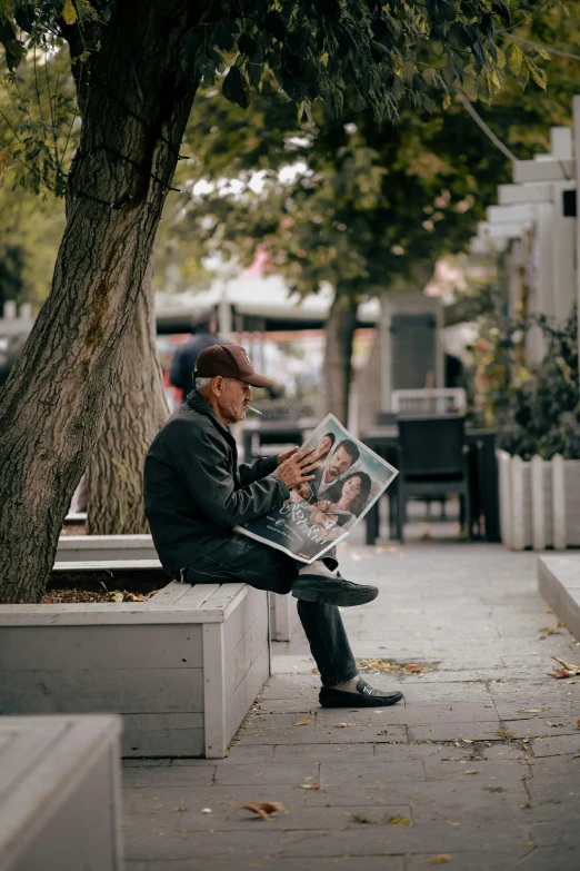 a man sits on the bench reading a paper