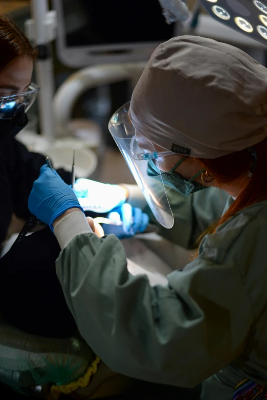 a dental technician at work on the teeth of a woman