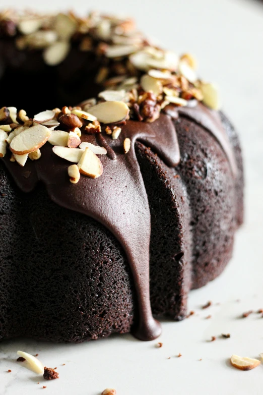 a bundt cake is topped with nuts and chocolate frosting