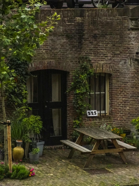 an empty picnic table sits outside a brick building