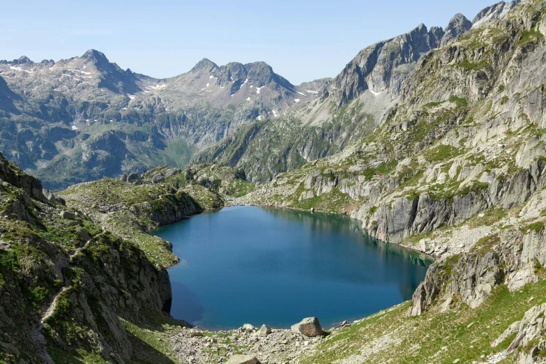 a picture taken in a mountain range with a lake surrounded by green mountains