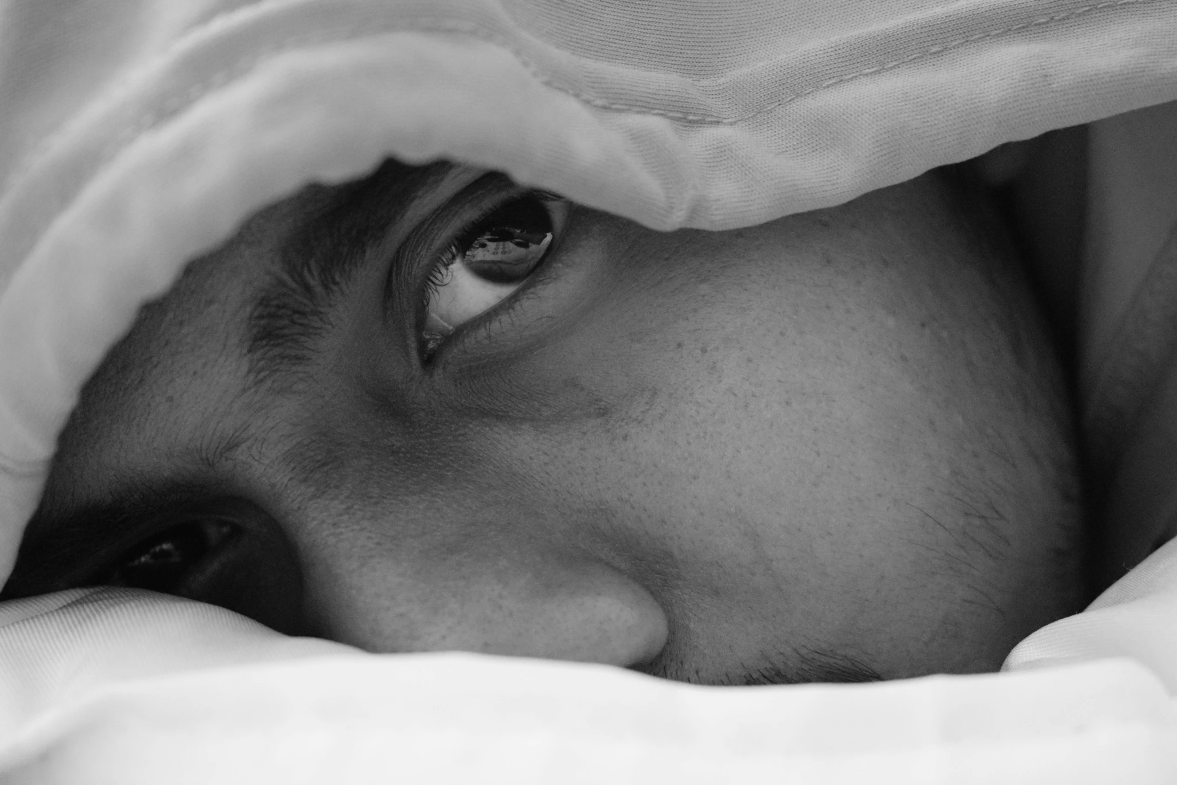 a man with his eyes covered under blankets