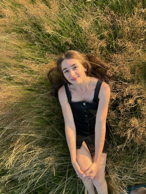 a young lady is laying on the grass