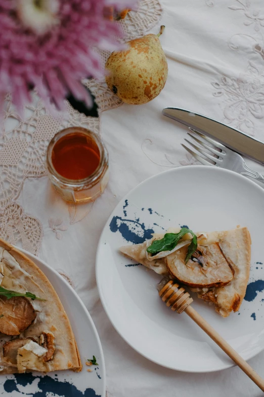 a table topped with two white plates with food on top of it