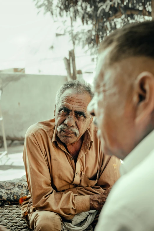 two men sitting on the ground talking