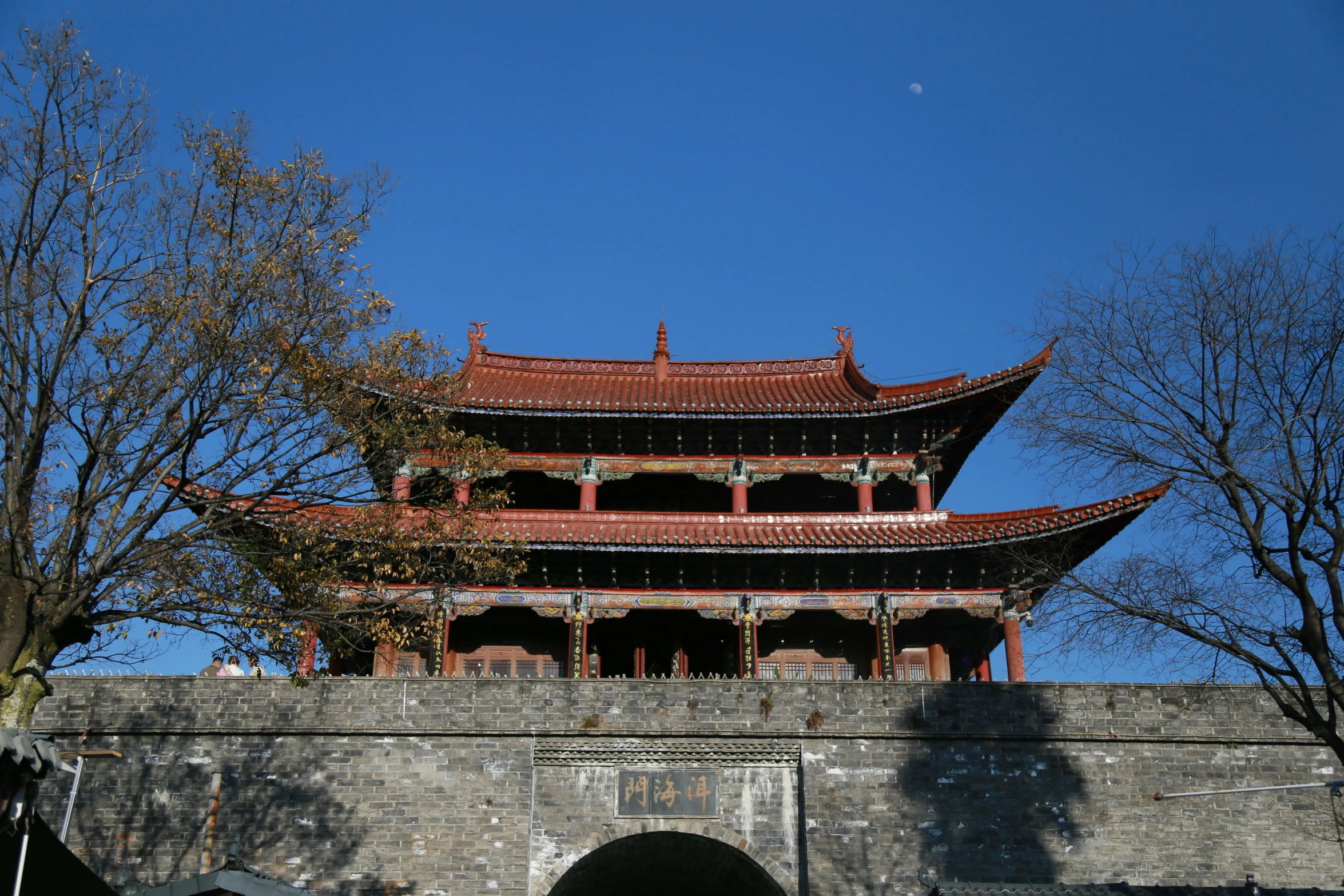 the pagoda stands near an ancient wall with trees in front