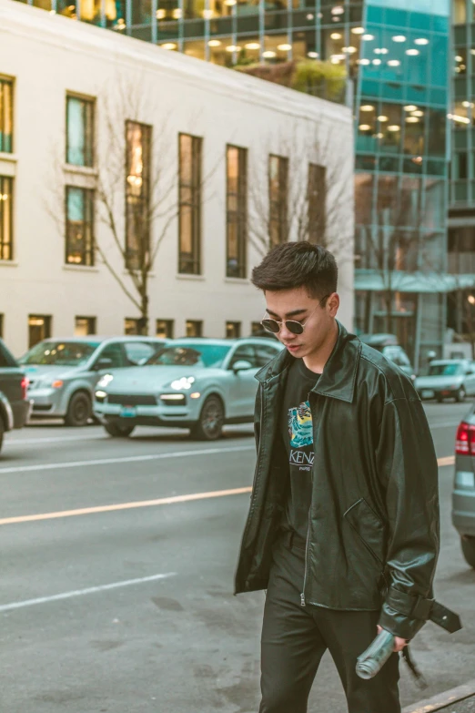 a man in a leather jacket standing on a street