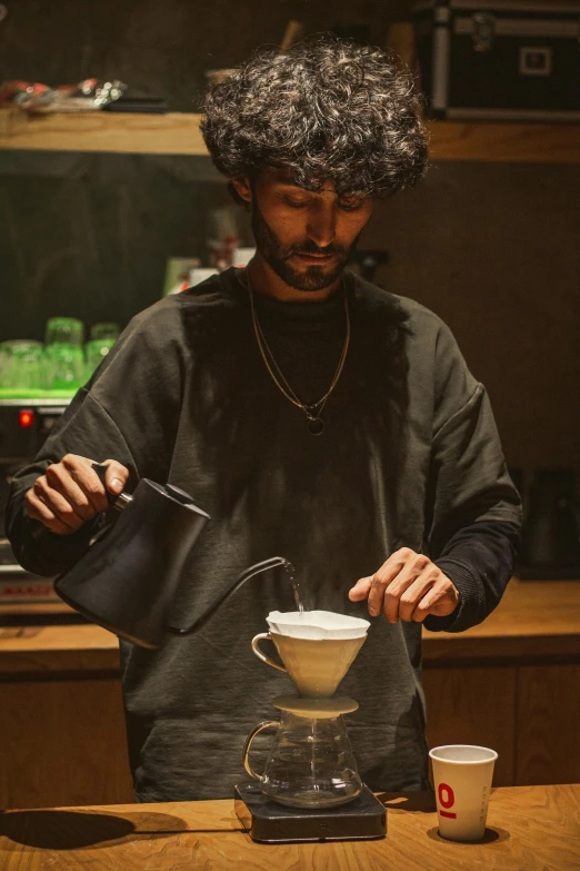 a man is making coffee in a kitchen