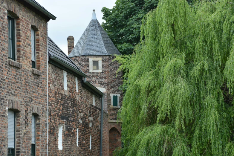 an old brick building next to green trees