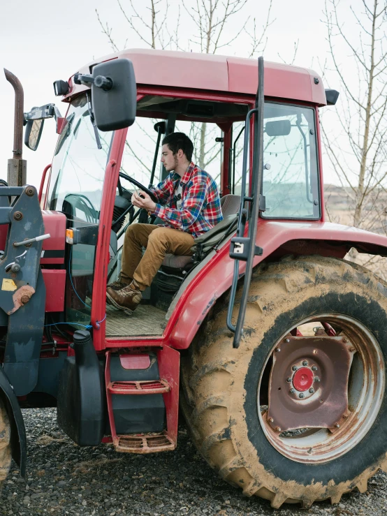 a farmer is driving the tractor and looking at the camera